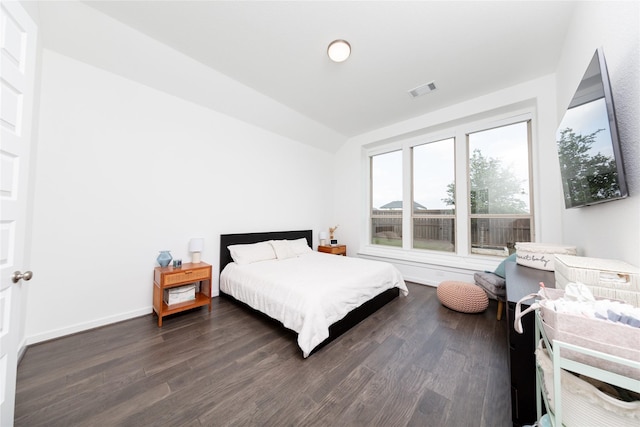bedroom featuring lofted ceiling, baseboards, visible vents, and wood finished floors