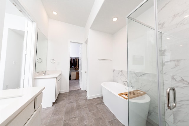 full bath with a stall shower, recessed lighting, a soaking tub, and two vanities