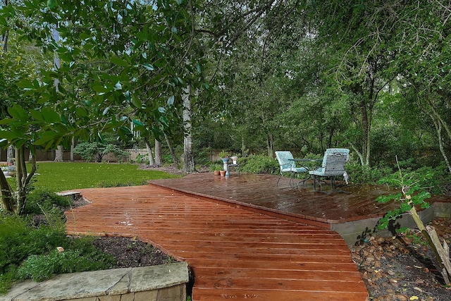 wooden terrace featuring a lawn and a fenced backyard