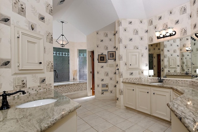 bathroom with lofted ceiling, tile patterned flooring, a sink, and a stall shower