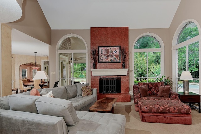 carpeted living area with vaulted ceiling, a fireplace, and plenty of natural light