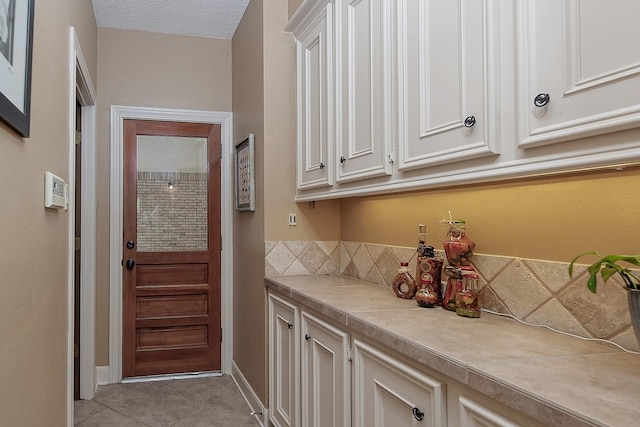 interior space with light tile patterned floors and baseboards