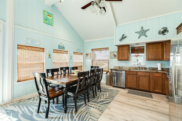 13022 Coronado Dr, Freeport, TX 77541 - dining area featuring a decorative wall, beam ceiling, high vaulted ceiling, light wood-type flooring, and a ceiling fan