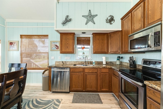 13022 Coronado Dr, Freeport, TX 77541 - kitchen with a sink, brown cabinets, light wood-style floors, and appliances with stainless steel finishes