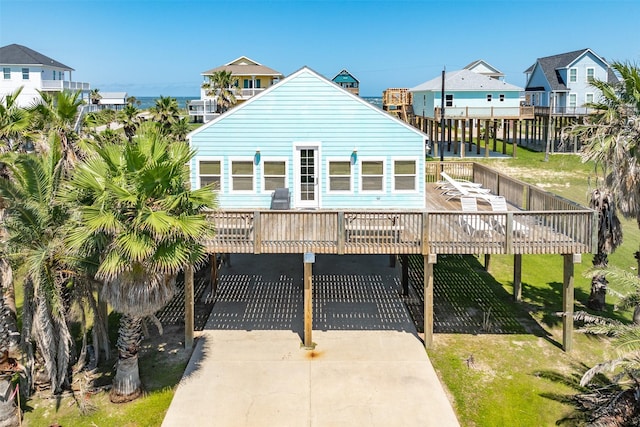 13022 Coronado Dr, Freeport, TX 77541 - view of front of house featuring a wooden deck, a front lawn, concrete driveway, and a residential view