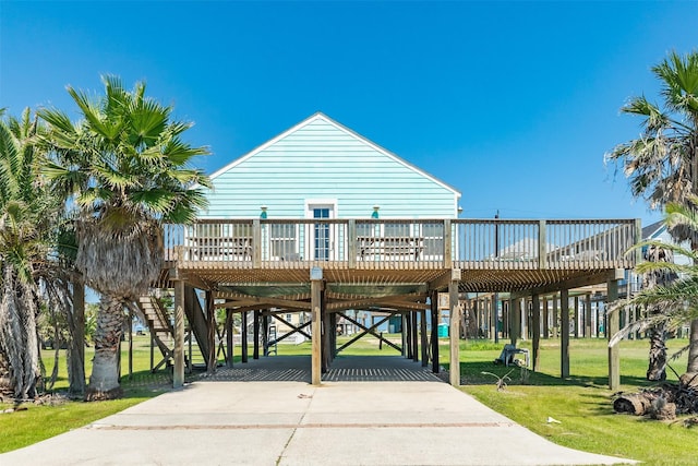 13022 Coronado Dr, Freeport, TX 77541 - view of property's community with a wooden deck, driveway, a carport, and a lawn