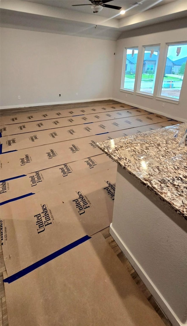 unfurnished living room with baseboards and ceiling fan