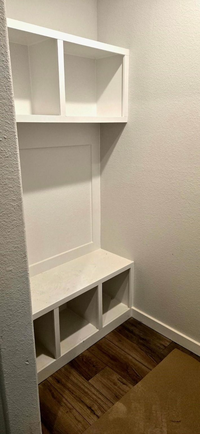 mudroom featuring baseboards and dark wood-type flooring