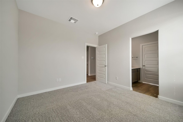 2563 Newport Breeze Dr, Katy, TX 77493 - unfurnished bedroom with dark carpet, baseboards, and connected bathroom