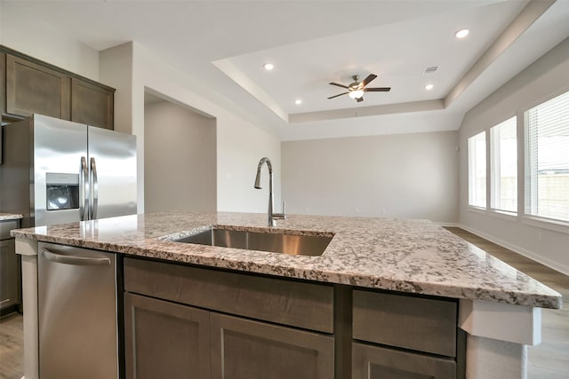 2563 Newport Breeze Dr, Katy, TX 77493 - kitchen featuring a sink, stainless steel appliances, light wood finished floors, light stone counters, and a ceiling fan
