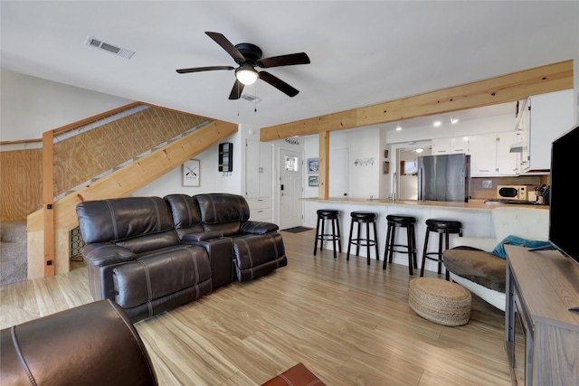 living room featuring ceiling fan, light wood-style flooring, and visible vents