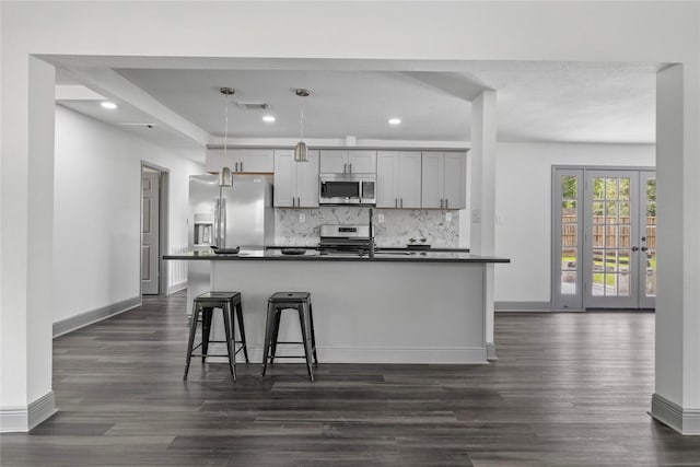 702 Pennington St, Houston, TX 77022 - kitchen with gray cabinetry, visible vents, dark countertops, tasteful backsplash, and appliances with stainless steel finishes