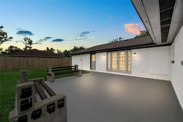702 Pennington St, Houston, TX 77022 - patio terrace at dusk featuring french doors, a yard, and fence