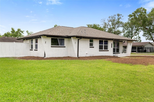 702 Pennington St, Houston, TX 77022 - back of property featuring brick siding, fence, and a lawn
