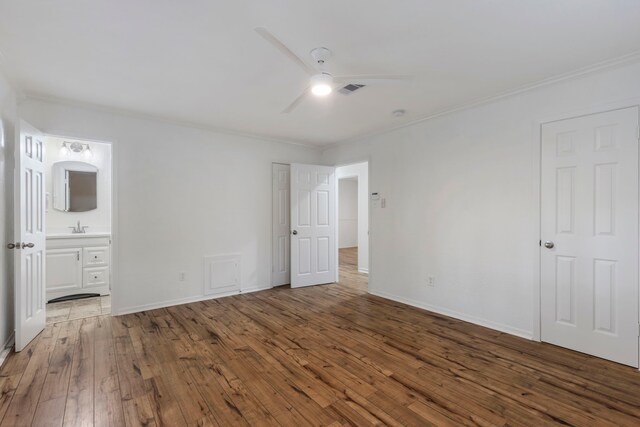 unfurnished bedroom featuring ornamental molding, hardwood / wood-style floors, and a sink