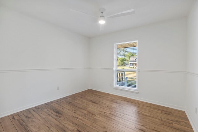 spare room featuring baseboards, a ceiling fan, and wood-type flooring