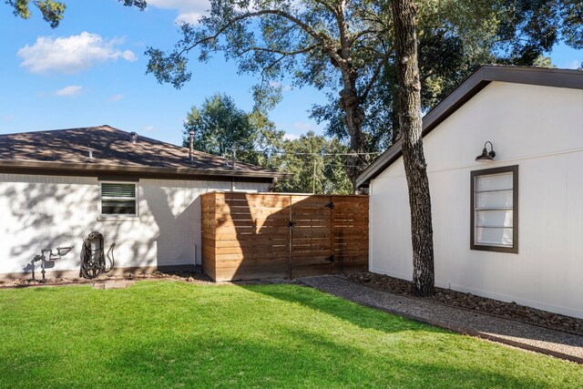 back of house with a lawn and fence