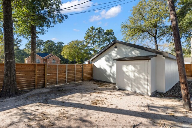 garage featuring a storage shed, fence, and a gate