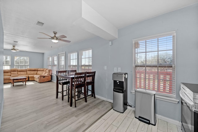 723 Frost Ave, Anahuac, TX 77514 - dining space with light wood-type flooring, visible vents, baseboards, and a ceiling fan