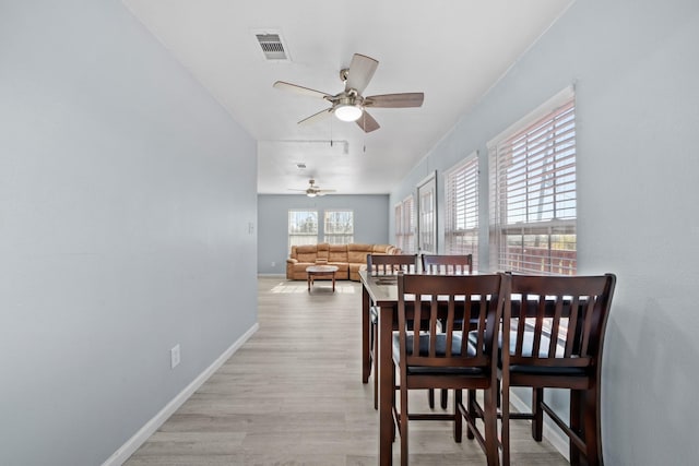 723 Frost Ave, Anahuac, TX 77514 - dining area with baseboards, ceiling fan, light wood-type flooring, and visible vents