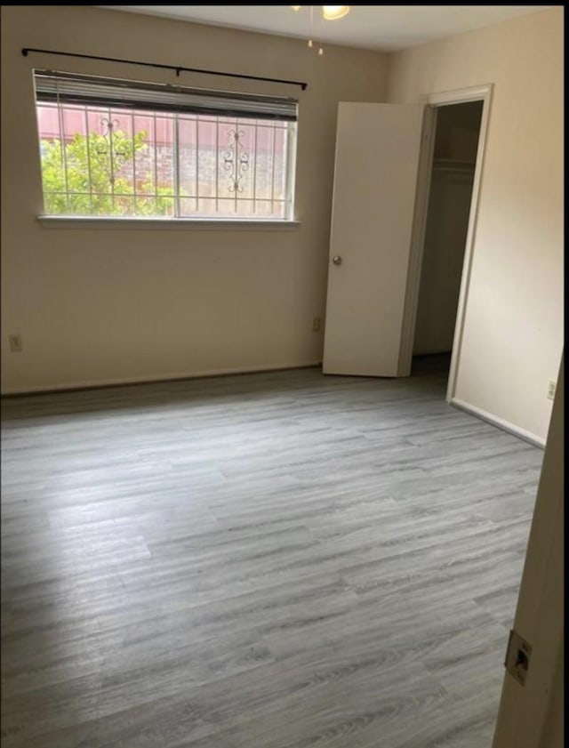 9006 Roos Rd, Houston, TX 77036 - empty room featuring a wealth of natural light, baseboards, and wood finished floors