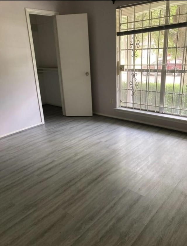 9006 Roos Rd, Houston, TX 77036 - unfurnished bedroom with wood finished floors, baseboards, and multiple windows