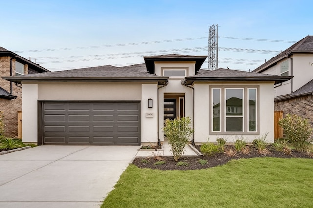 prairie-style house with driveway, stucco siding, a garage, and a front yard