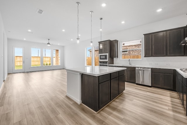 21818 Wycombe Terrace Way, Cypress, TX 77433 - kitchen with stainless steel appliances, plenty of natural light, light wood-style floors, and recessed lighting