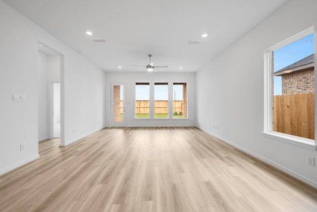 spare room featuring a wealth of natural light, visible vents, and a ceiling fan
