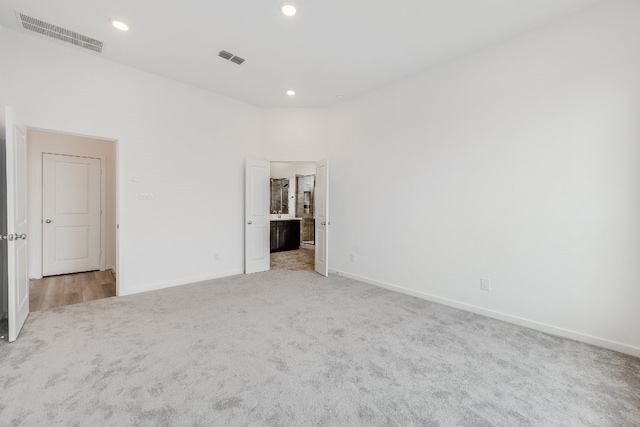 21818 Wycombe Terrace Way, Cypress, TX 77433 - unfurnished bedroom with light colored carpet, baseboards, recessed lighting, and ensuite bathroom