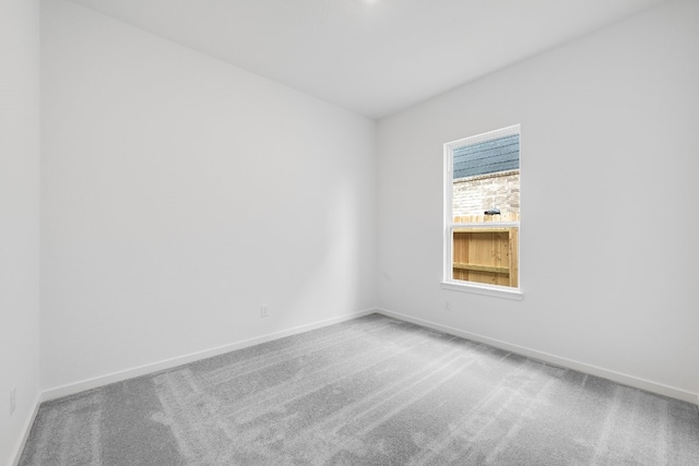 empty room with baseboards and carpet
