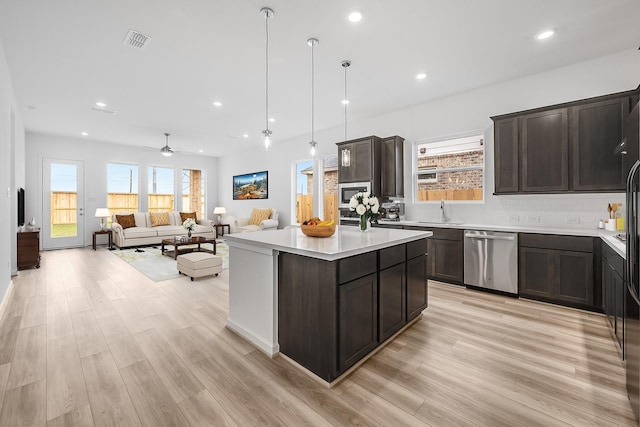 21818 Wycombe Terrace Way, Cypress, TX 77433 - kitchen featuring stainless steel appliances, dark brown cabinetry, tasteful backsplash, ceiling fan, and light wood-style floors