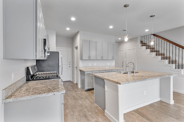 15010 Eagle Feather Ct, Houston, TX 77090 - kitchen featuring a sink, stainless steel appliances, light wood-type flooring, and a center island with sink