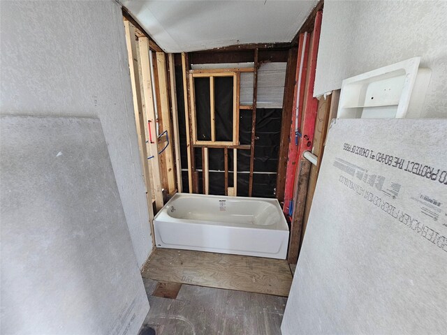 3229 Holman St Unit 4, Houston, TX 77004 - bathroom featuring a textured wall, a bath, and wood finished floors