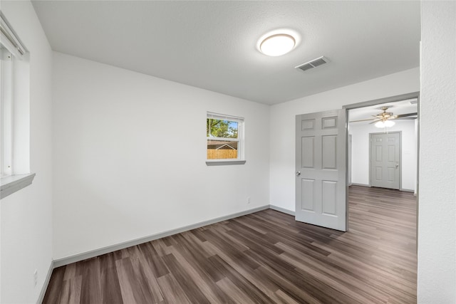 9211 Helmers St, Houston, TX 77022 - unfurnished room with visible vents, baseboards, ceiling fan, and dark wood-style floors