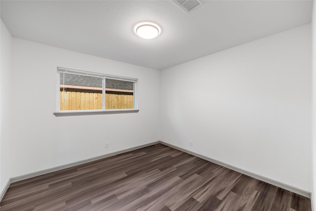 9211 Helmers St, Houston, TX 77022 - empty room featuring baseboards, dark wood finished floors, and visible vents