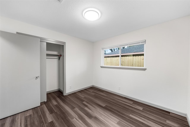 9211 Helmers St, Houston, TX 77022 - unfurnished bedroom with a closet, dark wood-type flooring, and baseboards