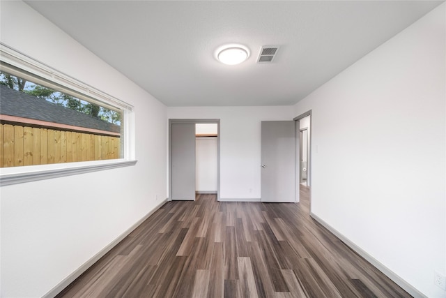 9211 Helmers St, Houston, TX 77022 - unfurnished bedroom with baseboards, dark wood finished floors, and visible vents