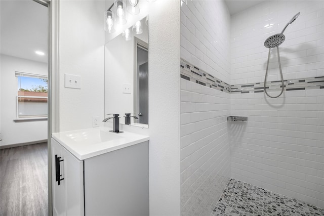 9211 Helmers St, Houston, TX 77022 - bathroom featuring vanity, tiled shower, and wood finished floors
