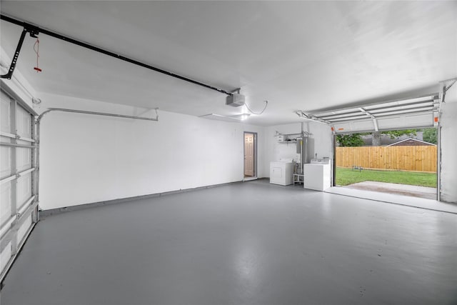 9211 Helmers St, Houston, TX 77022 - garage featuring washer and dryer, water heater, and a garage door opener