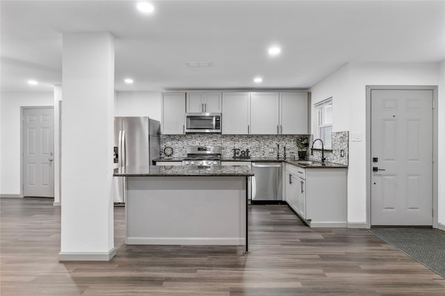 9211 Helmers St, Houston, TX 77022 - kitchen with a sink, dark stone countertops, a kitchen island, backsplash, and stainless steel appliances