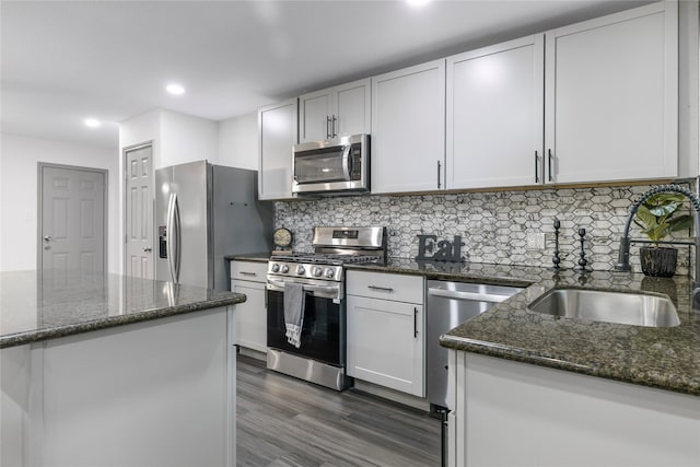 9211 Helmers St, Houston, TX 77022 - kitchen featuring dark stone countertops, appliances with stainless steel finishes, tasteful backsplash, and dark wood-style floors