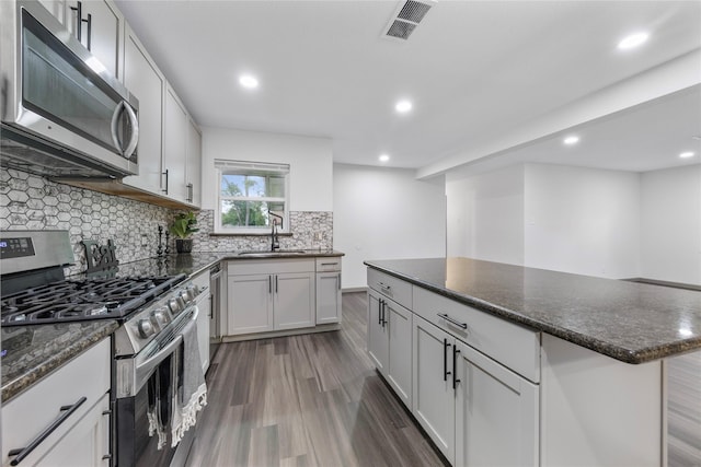 9211 Helmers St, Houston, TX 77022 - kitchen with a sink, visible vents, dark wood finished floors, recessed lighting, and appliances with stainless steel finishes