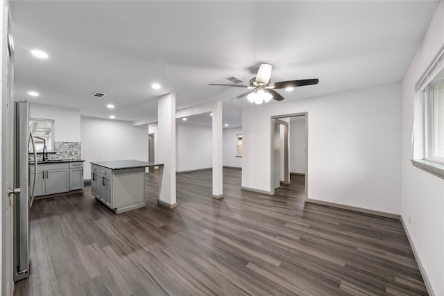 9211 Helmers St, Houston, TX 77022 - unfurnished living room with a ceiling fan, baseboards, visible vents, and dark wood-style floors