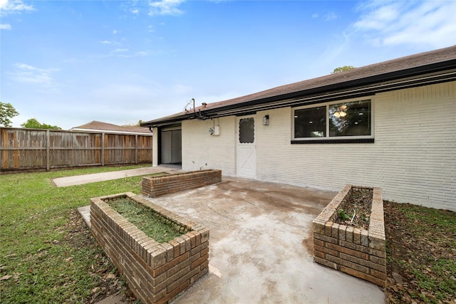 9211 Helmers St, Houston, TX 77022 - back of property with a patio area, fence, brick siding, and a lawn