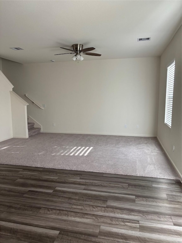 5811 Capri Forest Dr, Katy, TX 77493 - unfurnished living room featuring a ceiling fan, stairs, carpet floors, and wood finished floors