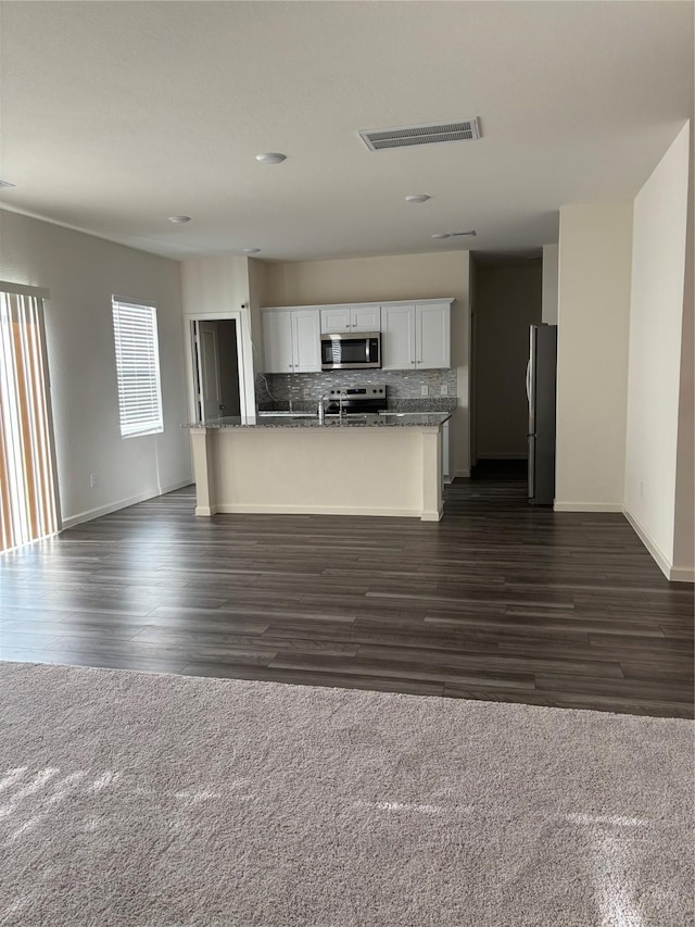 5811 Capri Forest Dr, Katy, TX 77493 - kitchen with stainless steel appliances, open floor plan, decorative backsplash, white cabinetry, and baseboards