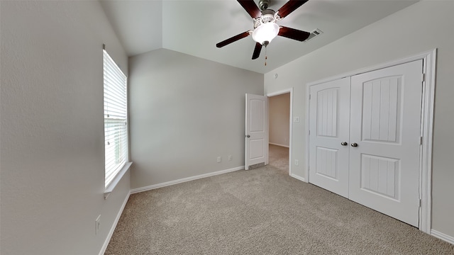 unfurnished bedroom with lofted ceiling, carpet floors, a closet, and multiple windows