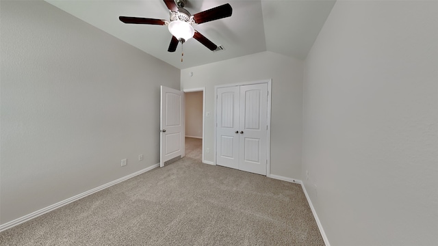 unfurnished bedroom featuring lofted ceiling, carpet, baseboards, and a closet