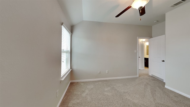 empty room with vaulted ceiling, ceiling fan, light colored carpet, and visible vents